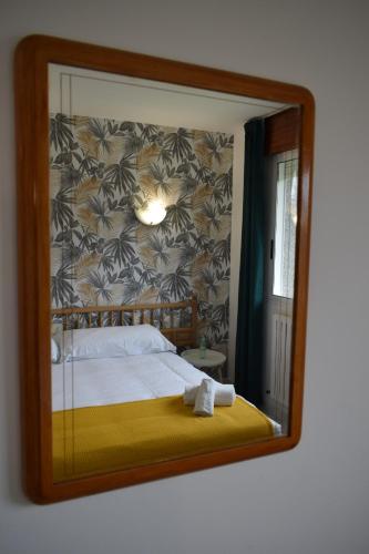 a mirror reflection of a bed in a room at Hotel VIDA Xunca Blanca in Sanxenxo