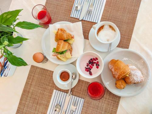 una mesa con platos de comida y una taza de café en Hotel Explorer, en Cervia