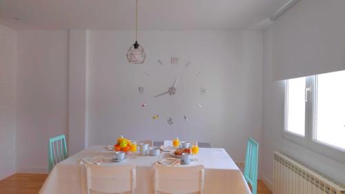 a white dining room with a table and chairs at APARTAMENTO LA REAL in Nájera
