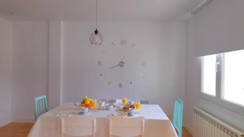 un comedor blanco con mesa y sillas en APARTAMENTO LA REAL, en Nájera