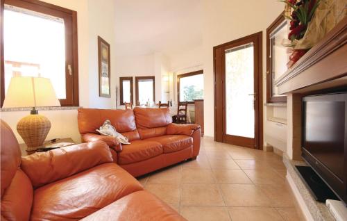 salon ze skórzaną kanapą i telewizorem w obiekcie Cozy Home In Costa Rei -Ca- With Wifi w mieście Monte Nai