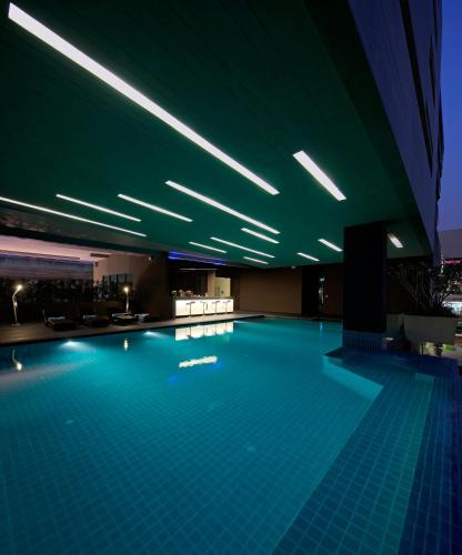 a swimming pool in a building with green lighting at Nine Forty One Hotel in Bangkok