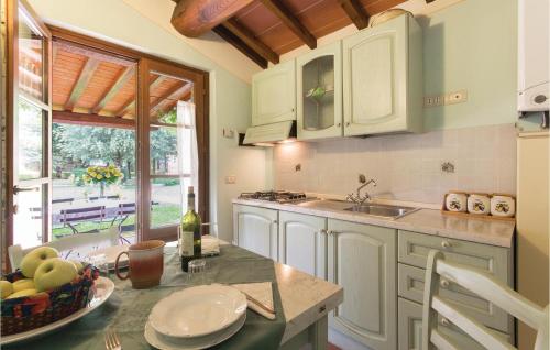 a kitchen with white cabinets and a table with a bowl of fruit at Il Nido in Panicarola