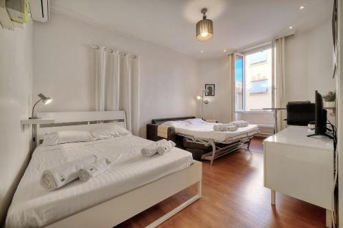 - une chambre avec 2 lits et une télévision dans l'établissement IMMOGROOM - Cosy Studio - Forville market - AC, à Cannes