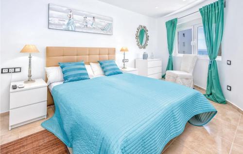a bedroom with a blue bed and a window at 2 Bedroom Amazing Apartment In Calahonda in Sitio de Calahonda