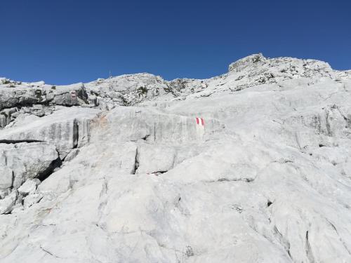 a snow covered mountain with red flags on it at Landhaus Seebacher in Spital am Pyhrn