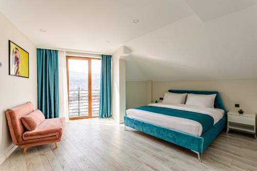 een slaapkamer met een bed, een stoel en een raam bij Orden Apart Hotel in Tbilisi City