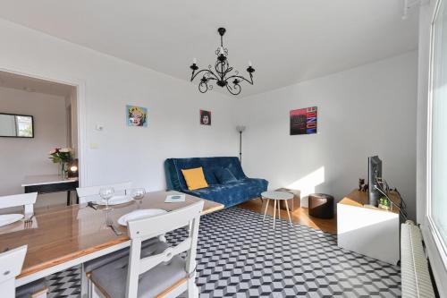 uma sala de estar com um sofá azul e uma mesa em Le Boileau - Apartment for 4 people parking and balcony CLOSE to the Lake em Annecy