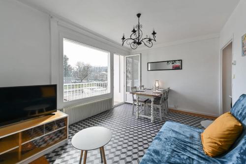 a living room with a couch and a tv and a table at Le Boileau - Apartment for 4 people parking and balcony CLOSE to the Lake in Annecy