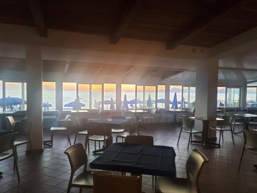 a restaurant with tables and chairs and a view of the ocean at Hotel Residence La Darsena in Agropoli