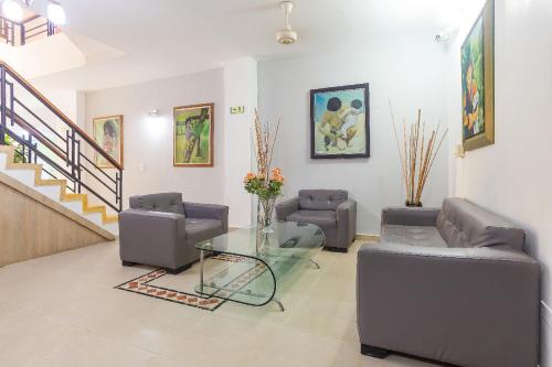 a living room with two couches and a glass table at Hotel Emberá in Apartadó