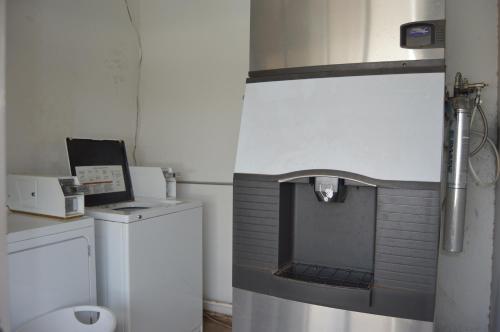 a small bathroom with a washer and dryer at Scottish Inns Weatherford in Weatherford