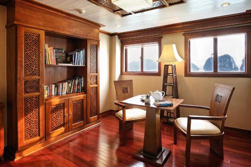 a dining room with a table and a book shelf at Paradise Peak Cruise in Ha Long