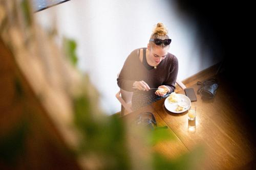 a woman sitting at a table with a plate of food at Tric Trac Hostel in Naples