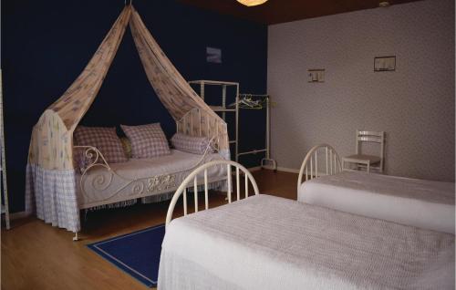 a bedroom with two beds and a canopy bed at 2 Bedroom Beautiful Home In Geffosses in Geffosses