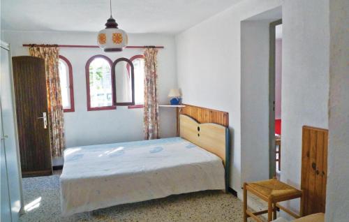 um quarto com uma cama num quarto com duas janelas em Beautiful Apartment In Calvi With 3 Bedrooms em Calvi