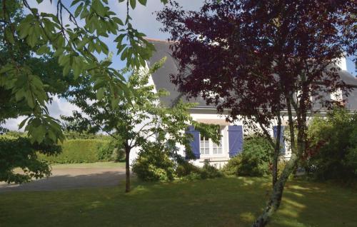 une maison blanche avec des arbres devant une cour dans l'établissement Nice Home In Pleuven With Wifi, à Pleuven