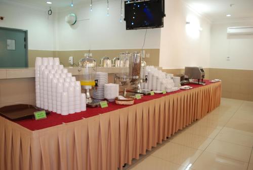 a long table with a bunch of cups on it at Akar Beach Resort in Port Dickson