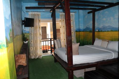 a bedroom with a bed and a balcony with a television at Huen Chan Thip in Chiang Rai