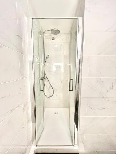 une douche avec une porte vitrée dans une salle de bain dans l'établissement La Bulle de Champagne, à Champagne-au-Mont-dʼOr