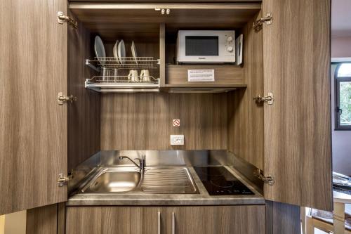 a small kitchen with a sink and a microwave at Baba Residences in Alassio