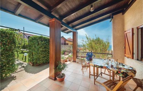 a patio with a table and chairs on a balcony at Stunning Apartment In Porto Alabe in Magomadas