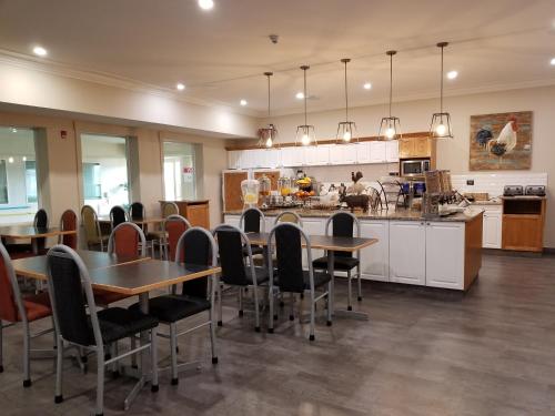 a kitchen and dining room with tables and chairs at Western Budget Motel Leduc #3 in Leduc