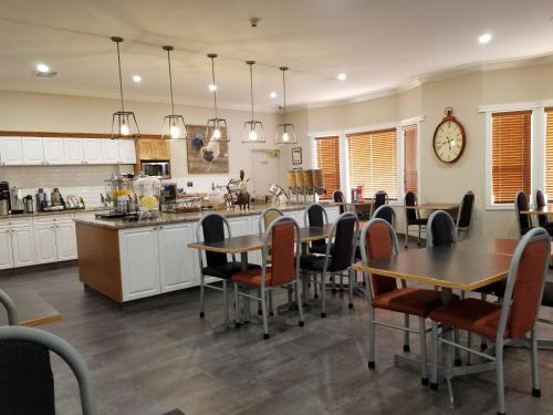 a large kitchen with tables and chairs and a counter at Western Budget Motel Leduc #3 in Leduc