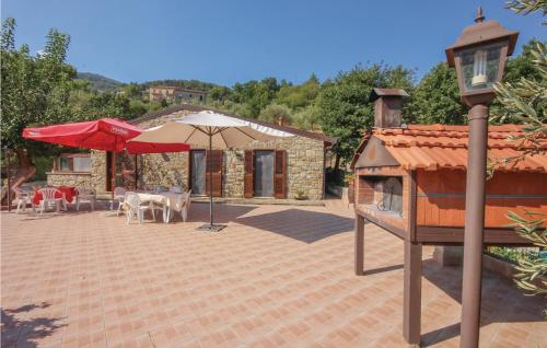 a patio with a table and an umbrella and a house at Villa Marisa in Perdifumo