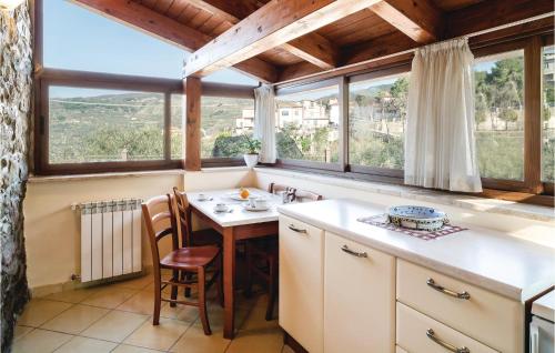 a kitchen with a table and chairs and windows at Villa Marisa in Perdifumo