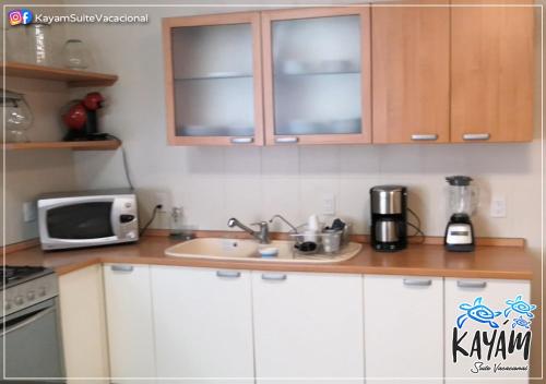 a kitchen with a sink and a microwave at KAYÁM Suite Vacacional in Veracruz