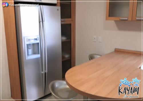 a kitchen with a stainless steel refrigerator and a table at KAYÁM Suite Vacacional in Veracruz