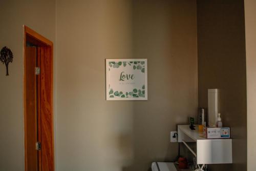 a bathroom with a sign that says love on the wall at Vila Bonita in Alto Paraíso de Goiás