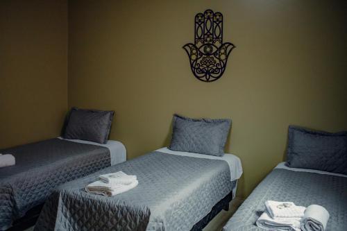 アウト・パライーゾ・デ・ゴイアスにあるVila Bonitaのベッド3台と壁掛け時計付きの部屋