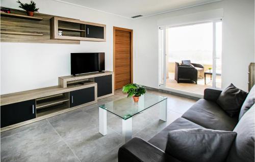 Una sala de estar con un sofá y un televisor. en Beautiful Apartment In Torrevieja, en Punta Prima
