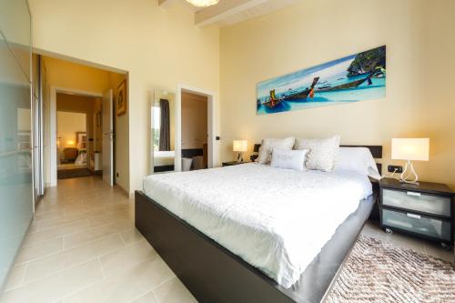 a bedroom with a large bed and a bathroom at Bini Sole - Villa de lujo con piscina en Menorca in Binibeca