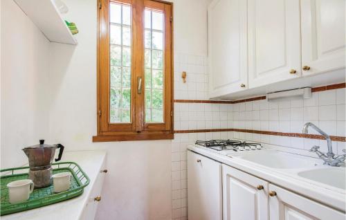 a white kitchen with a sink and a window at Solaria 2 in Massa