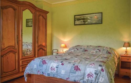 a bedroom with a bed and a large wooden cabinet at Nice Home In Plouaret With 3 Bedrooms And Wifi in Plouaret