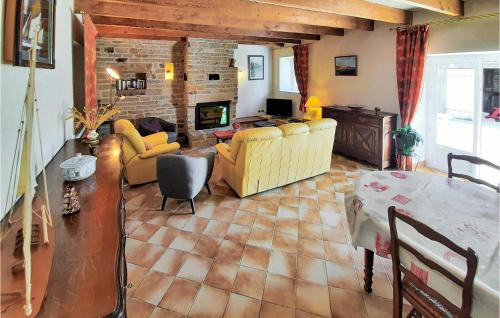 a living room with yellow furniture and a brick wall at Beautiful Home In Clohars Carnoet in Clohars-Carnoët
