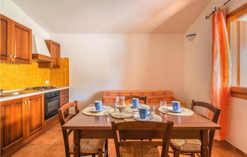a kitchen with a wooden table and chairs in a kitchen at Trilo 6 in Budoni