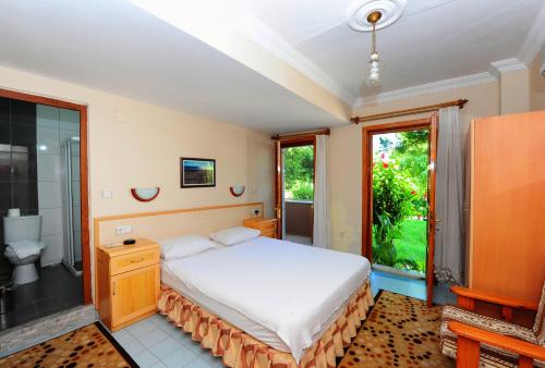 a bedroom with a large bed and a bathroom at Golden Pension in Patara