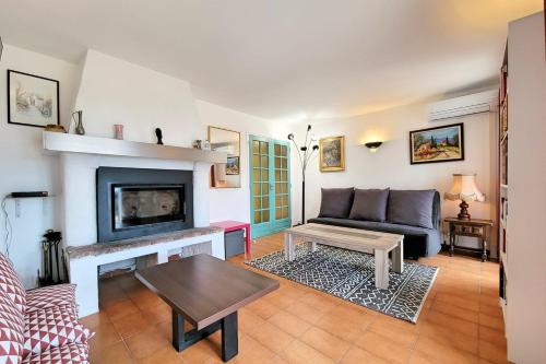a living room with a couch and a fireplace at Apartment Comfort Terrace Garden Wifi in Saint-Cyr-sur-Mer