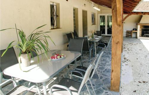a patio with tables and chairs and a table with plants at Beautiful Home In Eyliac in Saint-Laurent-sur-Manoire