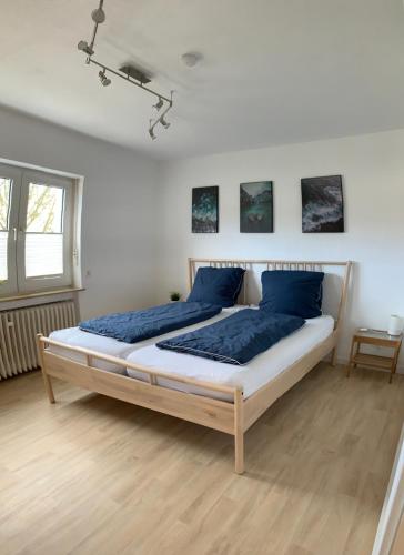 a bedroom with a large bed with blue pillows at Dokazien in Waldems