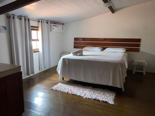 a bedroom with a large bed and a window at Casa em Paraty in Paraty