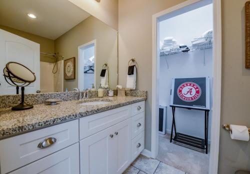 a bathroom with a sink and a large mirror at T-Town Cottage in Tuscaloosa