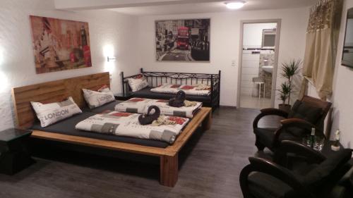 a bedroom with two beds and a living room at Gästehaus Metropolitan in Rust