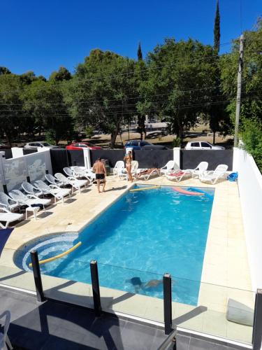 a swimming pool with chairs and people standing around it at Saint Uriel in Puerto Madryn