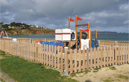 a wooden fence with a playground in front of the water at Stunning Apartment In Trevou Treguignec in Trévou-Tréguignec