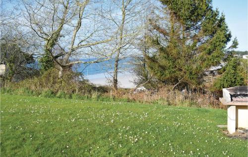 a bench sitting in the grass near the water at Stunning Apartment In Trevou Treguignec in Trévou-Tréguignec